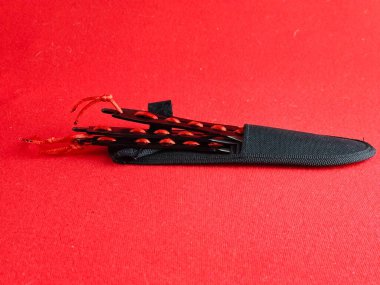 Savaş eğitimi ve spor amaçlı kırmızı arka plana atılan birkaç bıçak seti..