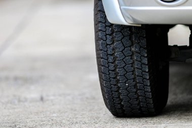 Araba lastiği, arabanın önünde, yolda. Yakından. 