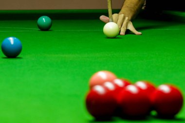 Yeşil bilardo masasında bilardo oynayan adam.