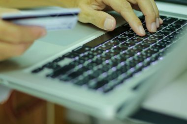 Adamın biri kredi kartıyla online alışveriş yaparak lobi klavyesiyle çalışıyor. İnternetten alışveriş kavramı.