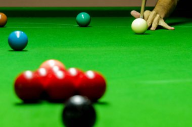 Yeşil bilardo masasında bilardo oynayan adam.