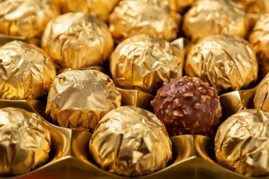 Çikolata ve fındık topu şekeri. Altın kaplama folyoda şekerleme..