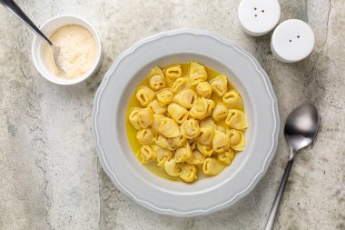 Sığır eti ve tavuk suyunda Tortellini. Aslen İtalyan bölgesi Emilia, Bologna 'dan yumurtalı makarna. Et, prosciutto, mortadella, sert peynir, yumurta karışımı ile doldurulmuş ve capon çorbasında servis edilmiş..