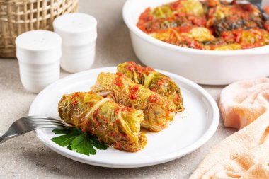 Meal with stuffed savoy cabbage with rice in a tomato sauce.