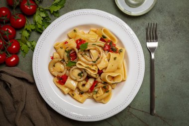 Italian pasta Calamarata made with  thick ring pasta paccheri, calamari or sliced squid, and tomato sauce.  Originates from Naples, the South of Italy. Directly above.