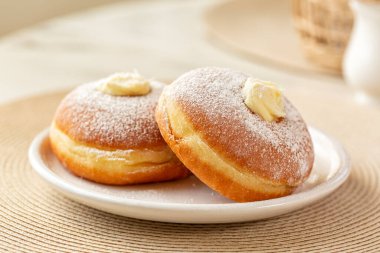 Close-up of Krapfen or berliner, or doughnut, or bombolone with cream filling, sugar powdered. 