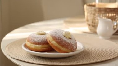 Kahvaltı bombolonisi, Krapfen ya da berliner ile kahvaltı hazırlamak, ya da donut, ya da kremalı bombolone. Sıcak çay dökme hareketi..