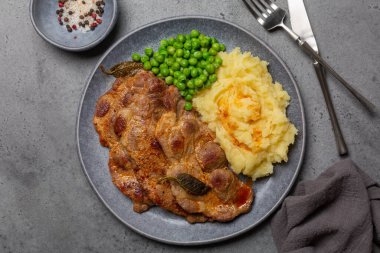 Baharatlı ve adaçaylı domuz bifteği, patates püresi ve haşlanmış bezelye.. 