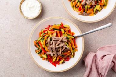 Salamura sebzeli sığır eti salatası, dolmalık biber, kabak, kereviz, soğan, havuç. Mayonez sosu. Bej arkaplan, kopyalama alanı.