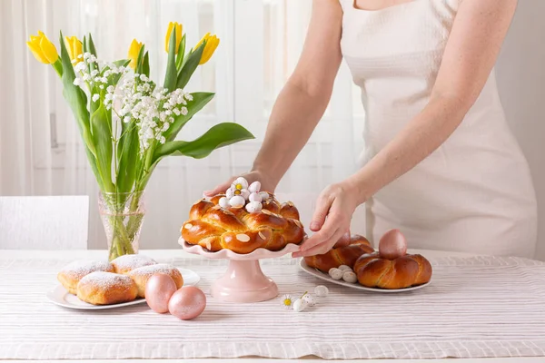 带着复活节糕点 糖果和春花准备餐桌的妇女 复活节快乐 背景浅 — 图库照片
