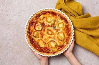 Pırasa, yumurta, pekorino peyniri ve kremalı el yapımı kiş pırasası. Tuzlu turta, fırında pişmiş. Vejetaryen yemeği. Üst görünüm, bej arkaplan.