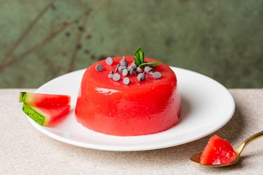 Sicilya yaz tatlısı gelo di melone, İtalya. Çikolata ve fesleğen yapraklarıyla süslenmiş karpuz hamuru, şeker ve nişasta ile yapılmış jöleli karpuz pudingi. Yeşil arkaplan.