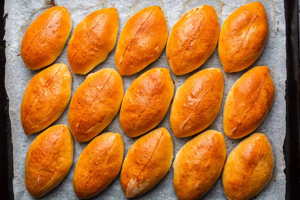 在烹调盘上烹调小馅饼或小馅饼 自制的烤酵母船形状的面包与卷心菜充填 东欧食品 — 图库照片