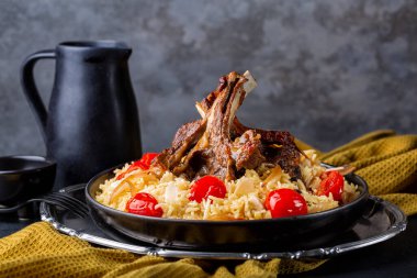 Yavaş kavrulmuş kuzu eti ve safran uzun pirinç ve sebze, soğan, domates ve badem. Peçeteli yemek masası. Haneeth, pilav, Mansaf, bacak ya da kabsa. Doğu yemekleri, karanlık arka plan..