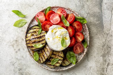 Burrata veya mozzarella peyniri ve sebzeli tabak, ızgara patlıcan, domates, fesleğen, grissini ve zeytinyağı. İtalyan yemeği, atıştırmalık.