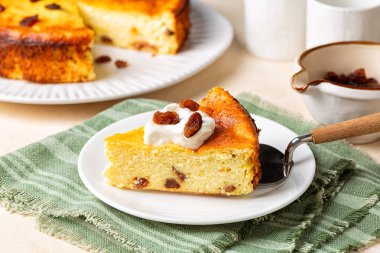 Bir parça ev yapımı süzme peynirli güveç ve kuru üzümlü turta.