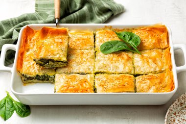 Casserol Spanakopita turtası, ev yapımı Yunan ıspanaklı böreği. Peynirli feta, doğranmış ıspanak, yeşil, yumurta, filo veya filo gübresi katmanlı.. 