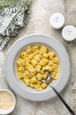 Sığır eti ve tavuk suyunda Tortellini. Geleneksel İtalyan Noel ana yemeği özellikle Bologna 'da. Et, prosciutto, mortadella, sert peynir, yumurta karışımı ile doldurulmuş ve capon çorbasında servis edilmiş..