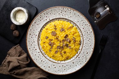 Lezzetli siyah mantarlı ve sert peynirli Saffron risotto. Özel sürgülü ya da bıçaklı Tuber Aestivum. Tabağın üst görünümü.