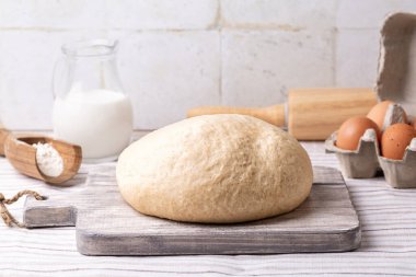 Temel Tatlı Maya Hamuru yapıyorum. Maya, şeker, süt yumurtası, buğday unu, tereyağı ve tuz karışımı. Mutfak masasındaki malzemeler, açık renkler..