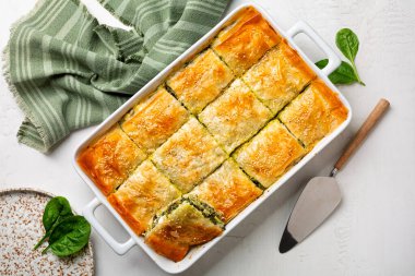 Spanakopita, ev yapımı Yunan baharatlı ıspanaklı turta. İçinde peynirli feta, doğranmış ıspanak, yeşil yumurta, filo ya da filo hamur işi var. Üst görünüm.
