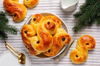 Ev yapımı St Lucia safran çörekleri. Lussekatt ya da Lussebulle, Cornish çaylı çöreği ya da revel bun olarak da bilinir. Noel süslemesi, üst manzara.