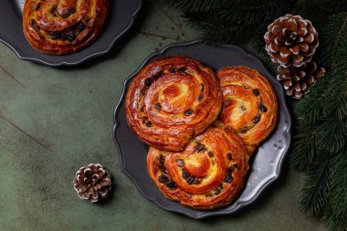 Acı kuru üzümler, salyangoz ya da acı rusz olarak da bilinir, muhallebi kreması ve kuru üzümlü, yeşil bir masada, noel pastası, ağaç dalı ve çam ağacıyla süslenmiş bir sarmal pastadır..