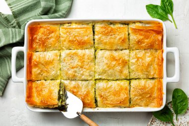 Spanakopita, Yunan baharatlı ıspanaklı turta. İçinde peynirli feta, doğranmış ıspanak, yeşil yumurta, filo ya da filo hamur işi var. Üst görünüm.