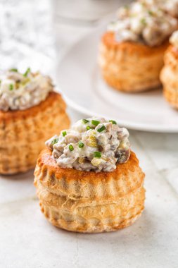 Kremalı Tavuk ve Mantar Vol Au menfezine yakın çekim. Puf böreği kabukları, bardaklar içeceklerle dolu. Festival sezonu için aperatifler, mini atıştırmalıklar. Dikey resim.