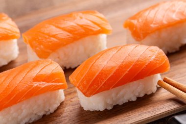 Kahverengi, bej arka planda somon suşisi nigiri. Kapat..