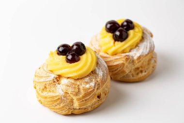 Zeppole di San Giuseppe, Zeppola - choux pastasından yapılmış fırında puf, krema ve kirazla doldurulmuş. Aziz Joseph Günü için geleneksel İtalyan pastası.. 