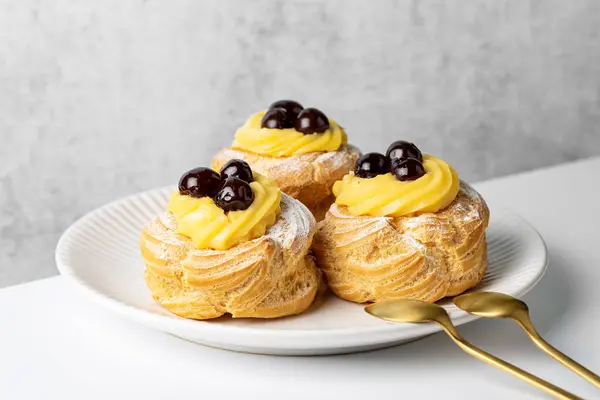 Zeppole di San Giuseppe, Zeppola - choux pastasından yapılmış fırında puf, krema ve kirazla doldurulmuş. Aziz Joseph Günü için geleneksel İtalyan pastası.. 