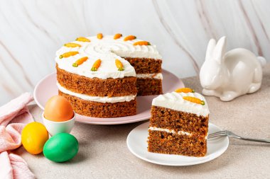 Paskalya yemeği. Bir dilim havuçlu kek, renkli yumurta ve tavşan. Tatil yemeği, hafif arka plan..