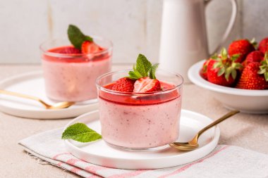 Bir çift tatlı, çilekli panna cotta fırında çilek, lezzetli, kremalı tatlı ve sos. Ev yapımı..