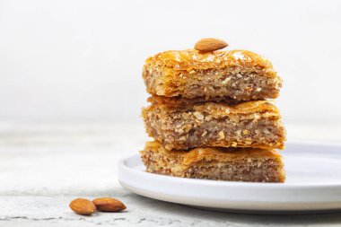 Bir yığın Baklava dilimi. Filo pastasından yapılmış, doğranmış badem fıstığı ile doldurulmuş ve şurup veya bal ile tatlandırılmış hamur tatlısı. Ev yapımı. Boşluğu kopyala.