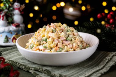 Rus salatası Olivier Noel 'de ya da yeni yıl masasında. Sebze, mayonez, bezelye, mortadella sosisi ve beyaz kasede servis edilen yumurtalardan yapılır..
