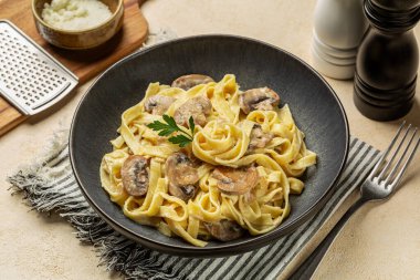Kremalı Alfredo makarna tagliatelle ya da mantarlı fettucine, soğan ve vejetaryen krema sosu. İtalyan yemeği.