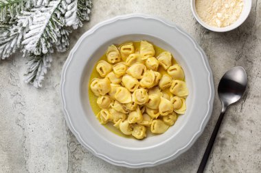 Sığır eti ve tavuk ya da horoz çorbası içinde Tortellini. Geleneksel İtalyan Noel ana yemeği özellikle Bologna 'da. Etli makarna, prosciutto, mortadella, parmesan peyniri..