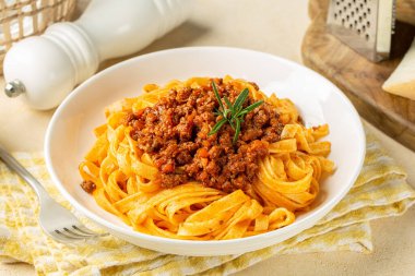 Tagliatelle al ragu ile beyaz tabağı kapatın. Et ve domates soslu uzun, düz yumurta makarnası ya da biberiyeli Bolonez sosu..
