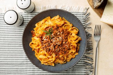 Tagliatelle al ragu ile tabağın üst görüntüsü - uzun, et soslu yumurta makarna ya da Bolonez sosu ve parmesan peyniri, biberiyeyle servis edilir..