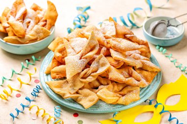 Melek kanatları ya da bugnes, bugie, ya da chvorost; faworki. Geleneksel karnaval tatlı kıtır börek kızartılmış ve üzerine pudra şekeri serpiştirilmiş..