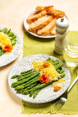 Kuşkonmaz Mimosa, üzerine haşlanmış yumurta ile servis edilen beyaz kuşkonmaz, biraz mimoza çiçeğine benziyor, yenilebilir viyola çiçeği ile süslenmiş. Dikey resim.