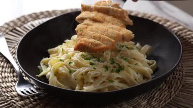Kızarmış tavuk göğsünü kremalı fettuccine Alfredo makarnasının üzerine koyuyorum.