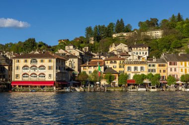 Orta San Giulio, Orta göl, İtalya - 25 Nisan 2025. Turistlerle dolu bir kasaba, teknelerle dolu bir liman, Lago Orta Bankası. İtalya 'nın Piedmont bölgesindeki Novara ili. Bahar zamanı, güneşli gün.