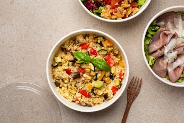 Sağlıklı beslenme çantaları, hazır yemek konsepti. Kızarmış sebzeli kuskus, biftek ve marul, cevizli vejetaryen salatası. Üst görünüm. 