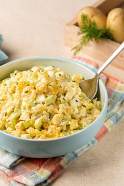 Patates salatasının dikey görüntüsü haşlanmış patates, haşlanmış yumurta, soğan, kereviz, hardal, turşu, mayonez ve kırmızı biber sosu..