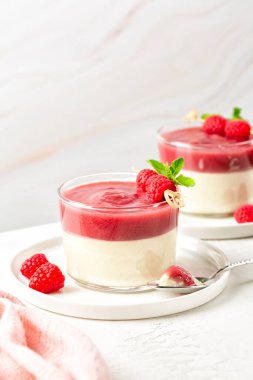 Ahududu soslu Bavyera kreması. Cam tatlıyı hazırla. Yumurta bazlı krem şantili krema ve jelatin. Dikey resim. 