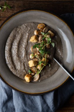 Sağlıklı vejetaryen mantar çorbası ve kraker, düğme mantarı ve hindistan cevizi kreması, koyu kırsal arka plan