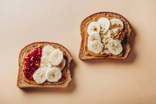 stock image Various kind of open sandwiches with berry jam and banana. Made from wholegrain bread and different nut butter, such as peanut butter and crunchy cashew or almond butter