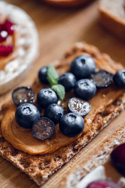 Open sandwich with blueberries. Made from wholegrain crispbreads and peanut butter, healthy nutritious snack option